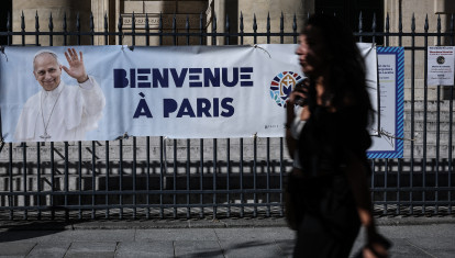 Una pancarta con la imagen del papa León XIV y el mensaje «Bienvenidos a París» adorna las rejas de la iglesia de Notre-Dame-de-Lorette mientras un peatón pasa por allí