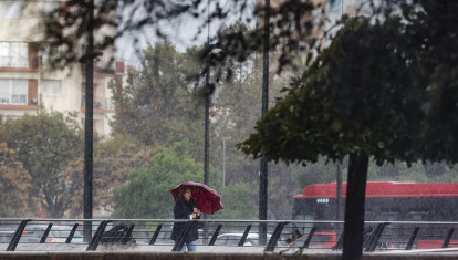 Imagen de una mujer protegiéndose de la lluvia en Valencia