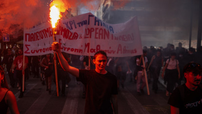 Un manifestante sostiene una bengala mientras estudiantes, profesores y funcionarios participan en una concentración para protestar contra el alto costo de la vida