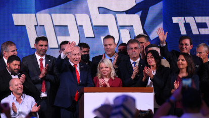 El primer ministro israelí, Benjamin Netanyahu (centro izquierda), saluda a sus seguidores junto a su esposa Sara en el mitin de la noche electoral tras el anuncio de los primeros sondeos a pie de urna, en Jerusalén