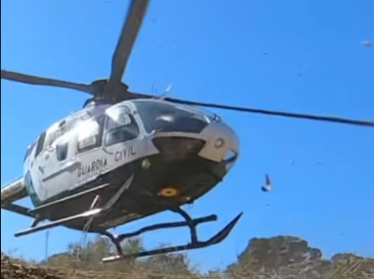 El helicóptero de la Guardia Civil tomando tierra junto a los moteros