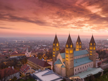 Vista nocturna de la ciudad de Pécs y su catedral iluminada