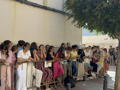 Niños y niñas esperan a las puertas de la Jefatura Superior de Policía de Ceuta para que les registren este mes de agosto
