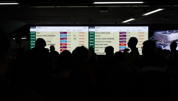 Viajeros afectados observan los paneles en Atocha