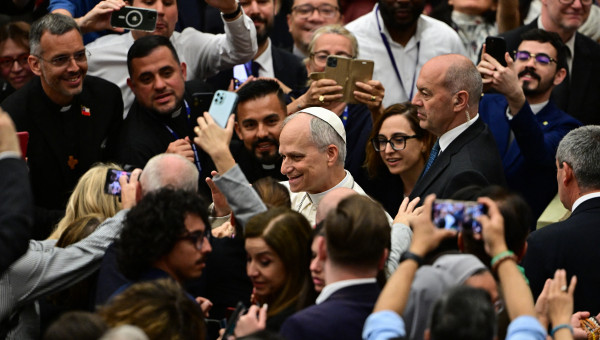 Pope Leo XIV (C) meets with journalists using smartphones during an audience to representatives of the media, at Paul-VI hall in The Vatican, on May 12, 2025. (Photo by Tiziana FABI / AFP)