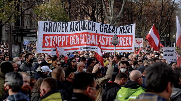 Manifestantes marchan el viernes en Viena bajo una pancarta que reza «Gran intercambio, gran reinicio, detengan la basura globalista»