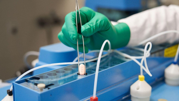 Un técnico maneja una pastilla de Paxlovid en un laboratorio de Pfizer en Alemania