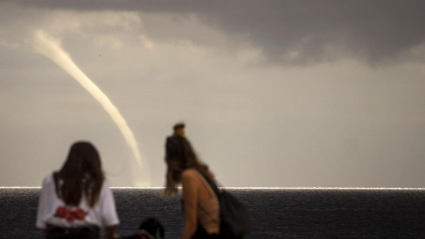 Dos personas contemplan una nube embudo en Barcelona en 2020