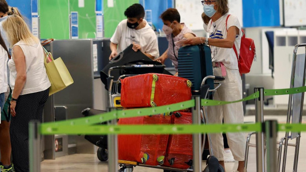 Viajeros esperan para facturar sus maletas en un mostrador del aeropuerto Adolfo Suárez Madrid-Barajas