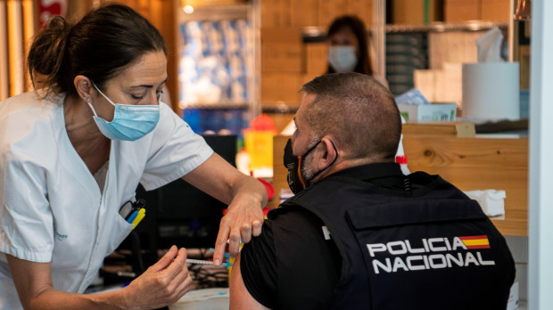 Un agente de la Policía Nacional recibe la segunda dosis de la vacuna contra la covid-19, este miércoles en el Hospital Son Espases, en Mallorca, que hoy ha comenzado a vacunar con la segunda dosis a trabajadores esenciales que habían recibido hace semanas una primera de AstraZeneca, en seis líneas habilitadas únicamente para este grupo en el centro sanitario palmesano. Cinco líneas están dedicadas a inyectar la segunda dosis de AstraZeneca a quienes han firmado un consentimiento informado para ello, y una para los que han elegido como segunda dosis la vacuna de Pfizer