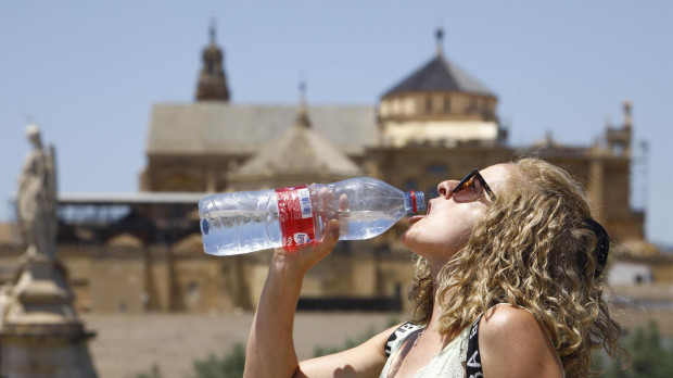Una turista bebe agua para combatir el calor, en Córdoba, ante las altas temperaturas que registra la Península por la ola de calor