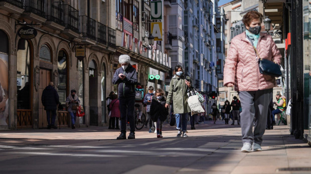 Varias personas mayores caminan por una calle céntrica de Vitoria.