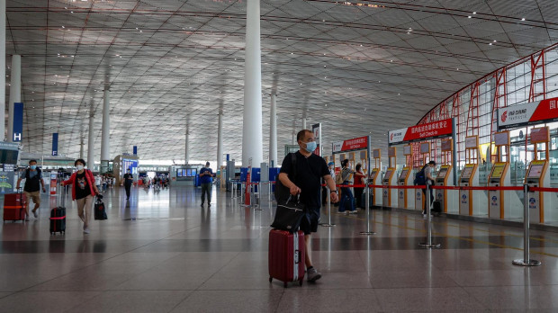 Varias personas caminan por el Aeropuerto Internacional de Pekín, en China, este miércoles. China ha reducido el periodo de cuarentena de las llegadas del extranjero con la permanencia de siete días en un centro gestionado por el gobierno y tres días en arresto domiciliario
