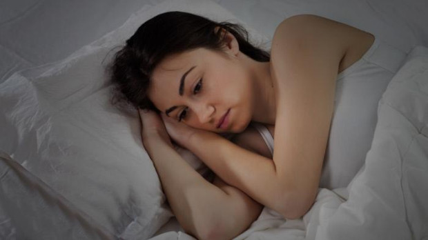 Mujer con insomnio a causa del calor
