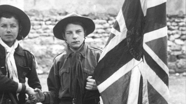 Scouts franceses y británicos, con sus respectivas banderas nacionales, dándose la mano 1912