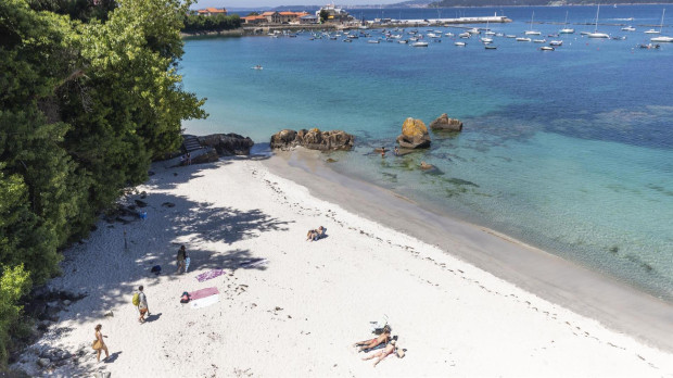 Varias personas se bañan y toman el sol en una playa del municipio de Marín, Pontevedra, Galicia