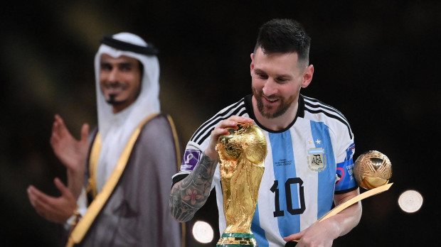 Argentina mira la Copa del Mundo mientras sostiene el trofeo al Mejor Jugador del Torneo