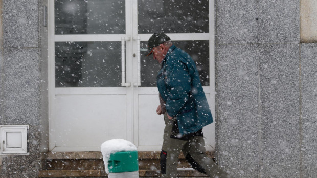 Un hombre camina por una calle cubierta de nieve