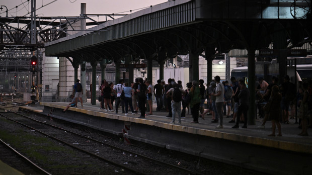 People wait at the Constitucion train station in Buenos Aires on March 1st, 2023, following an outage caused by a fire which affected the high-voltage system. - A massive power outage caused by a fire in a field near the high-voltage power lines that connect to the Atucha 1 nuclear power plant, affected millions of people in part of Buenos Aires and several provinces for at least two hours, authorities stated. (Photo by Luis ROBAYO / AFP)