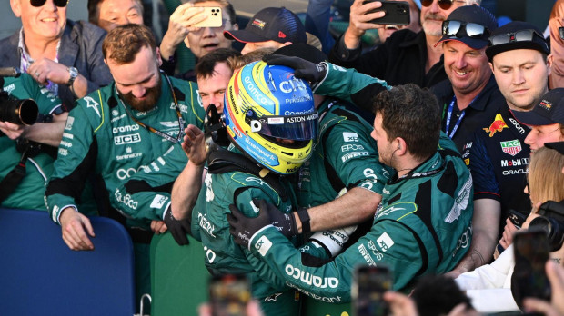 Fernando Alonso celebra con los mecánicos de Aston Martin su podio en Australia