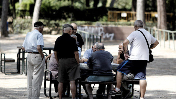 Varios pensionistas juegan al dominó en un parque de Madrid.