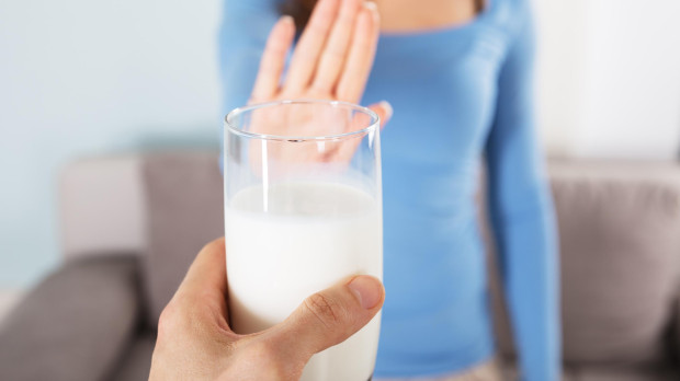 Close-up Of A Woman Rejecting Glass Of Milk At Home