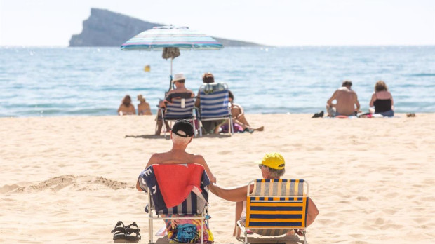 Numerosas personas se bañan y toman el sol en la playa de Poniente, Benidorm, Alicante