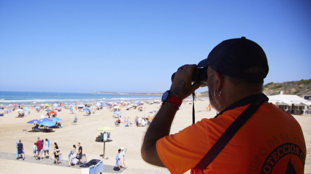 Un vigilante de la playa observa a los bañistas desde su torre en la playa de la Fontanilla en Conil de la Frontera