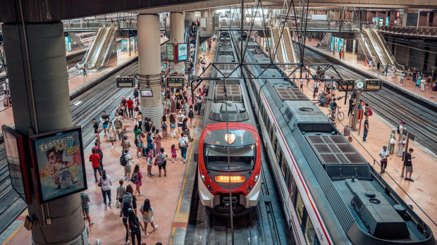 Varias personas en el andén de un tren de cercanías en la estación Almudena Grandes-Atocha