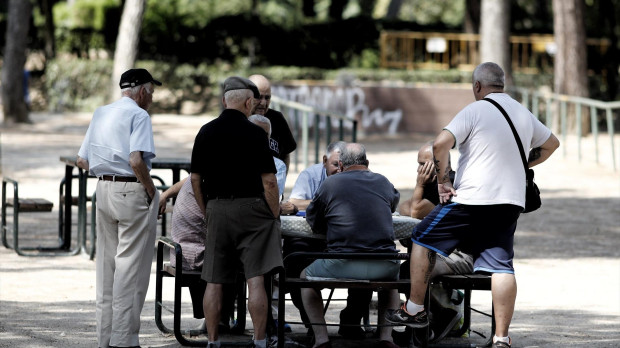 Varios pensionistas juegan al dominó en un parque de Madrid.