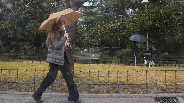 Una mujer se protege de la lluvia en Madrid.