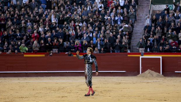 El torero Román Collado saluda al público tras ser embestido por un toro este domingo, durante la Feria de Fallas 2024, en Valencia