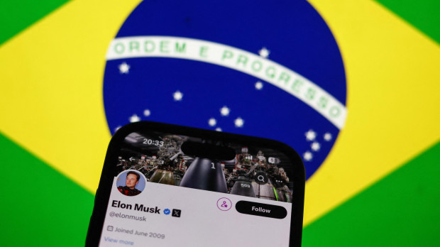 La cuenta de Elon Musk en X en la pantalla de un teléfono sobre una bandera de Brasil