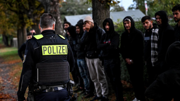 Inmigrantes hacen fila después de ser detenidos por la Policía en la frontera germano-polaca cerca de Frost