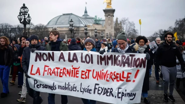 Manifestantes sostienen un pancarta durante la marcha de protesta celebrada en Paris contra la ley francesa sobre inmigración