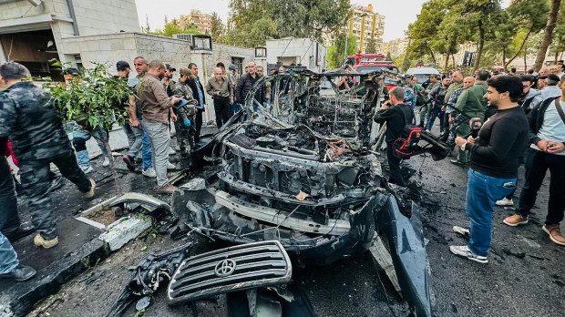 Los servicios de emergencia y seguridad sirios inspeccionan los restos de un automóvil que explotó en Damasco el 21 de octubre de 2024.