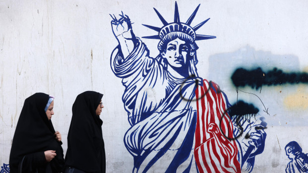 Mujeres iraníes pasan junto a un mural que representa a la Estatua de la Libertad con el brazo que porta la antorcha roto, pintado en las paredes exteriores de la antigua embajada de Estados Unidos, en Teherán