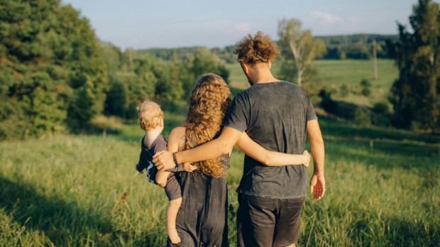 Una familia joven, frente a un paisaje arbóreo