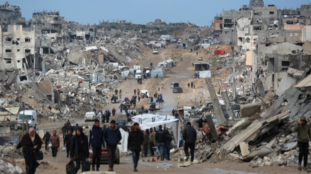 Palestinos desplazados caminan por un camino embarrado en medio de la destrucción en Jabalia, en el norte de la Franja de Gaza