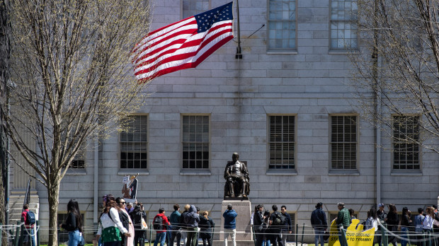 Manifestantes con pancartas se congregaron alrededor de la estatua de John Harvard en Harvard Yard tras una protesta contra los ataques del presidente Donald Trump a la Universidad