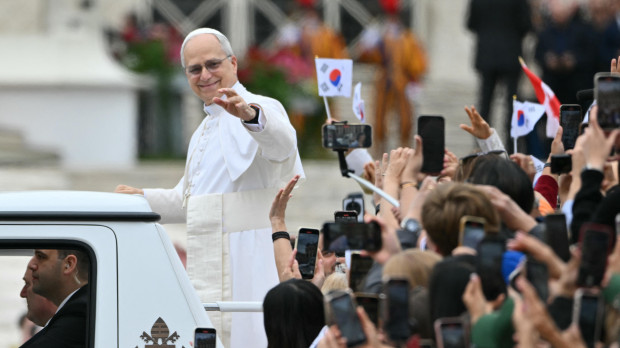 Pope Leo XIV waves to the crowd during the weekly general audience at St Peter's Square in The Vatican on May 21, 2025. (Photo by Alberto PIZZOLI / AFP)