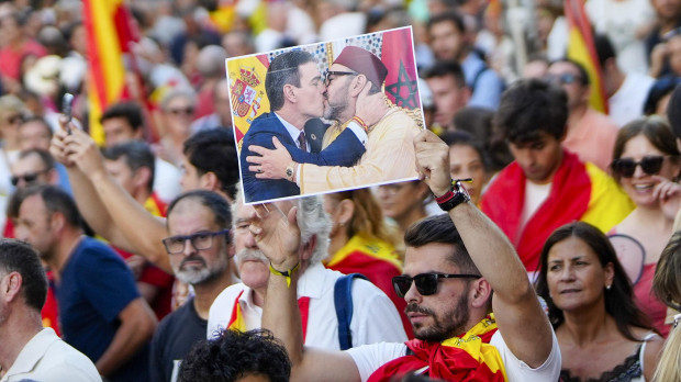 Un ciudadano sostiene un fotomontaje de Sánchez besando a Mohamed VI en la concentración de Madrid