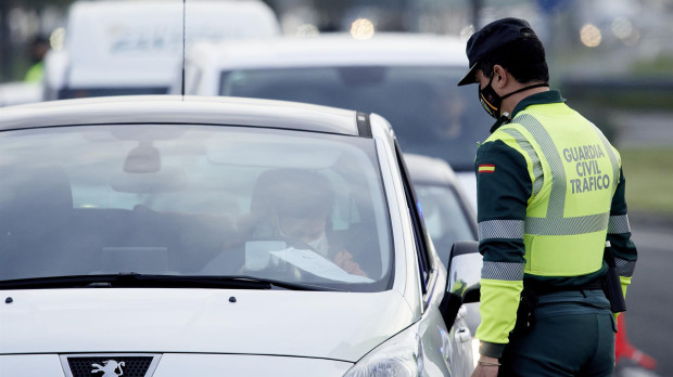 Un agente de la Guardia Civil le pide la documentación al conductor de un vehículo durante un control
