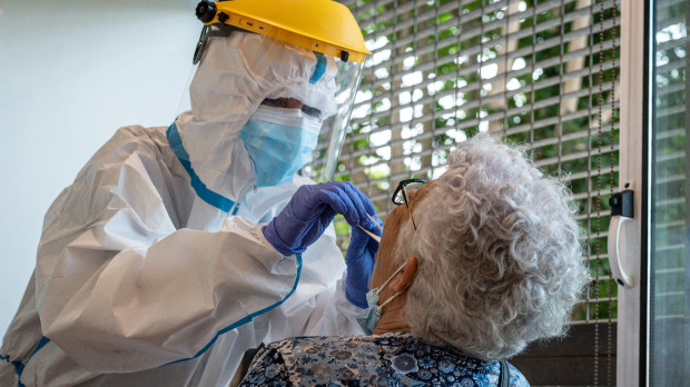 Un sanitario le practica una PCR a una usuaria en una residencia para mayores