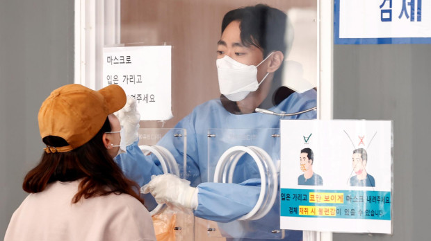 Un sanitario le practica un test contra la covid a una persona en Corea del Sur
