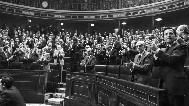 El presidente del Gobierno, Adolfo Suárez (d); el vicepresidente, Manuel Gutiérrez Mellado (2d), otros miembros del ejecutivo y diputados de UCD, aplauden después de ser aprobado por el pleno del Congreso el texto del proyecto constitucional, por 326 votos a favor, 6 en contra y 13 abstenciones