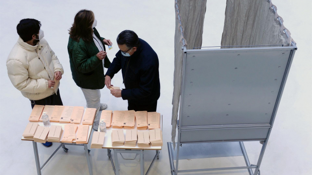 Tres personas preparan su papeleta de votación en un colegio electoral de Valladolid