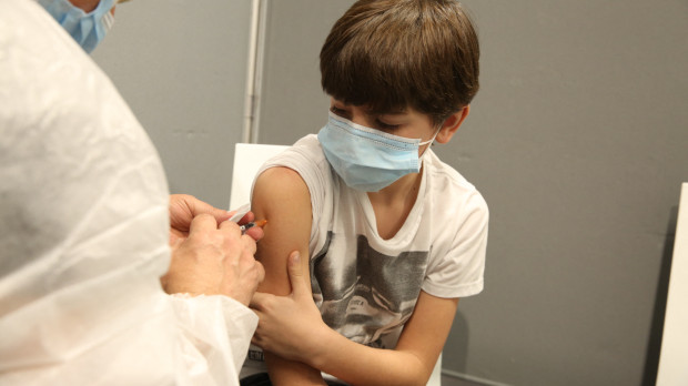 Enfermera vacunando a un niño menor de once años