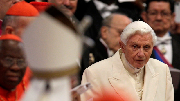 Pope Emeritus Benedict XVI looks at Pope Francis, left with back to camera, arriving as he attends a consistory inside the St. Peter's Basilica at the Vatican, Saturday, Feb.22, 2014.