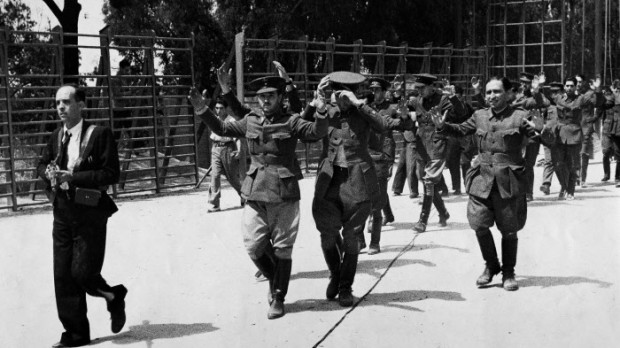 Rebel officers, with their hands raised, are marched under armed guard from the Montana barracks in Madrid, July 27, 1936. A few moments later they were sentenced to death and shot, the start of the "red terror." (AP Photo)